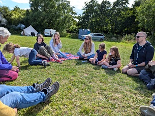 A group of people sat playing laughter yoga at camp